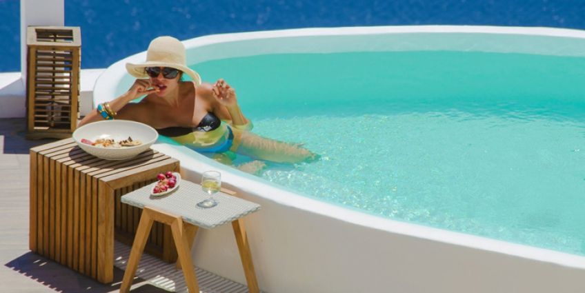 Woman in pool in Aqua Suites Hotel in Santorini, Greece