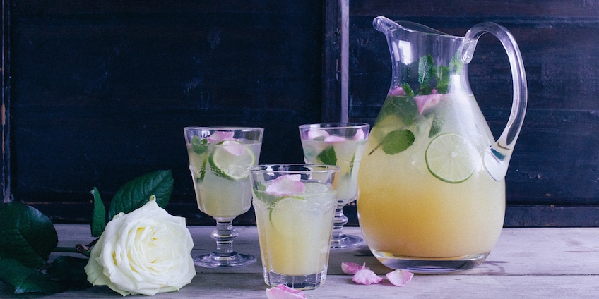 Jug of cocktail mix with garnished glasses